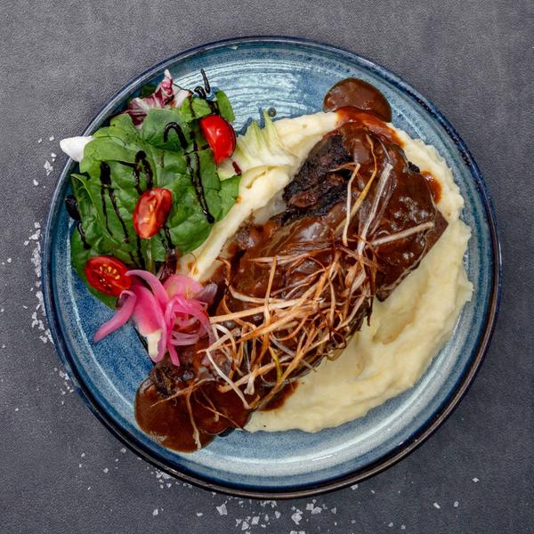 Coastă de vită gătită lent în vin, servită cu piure cremos de cartofi